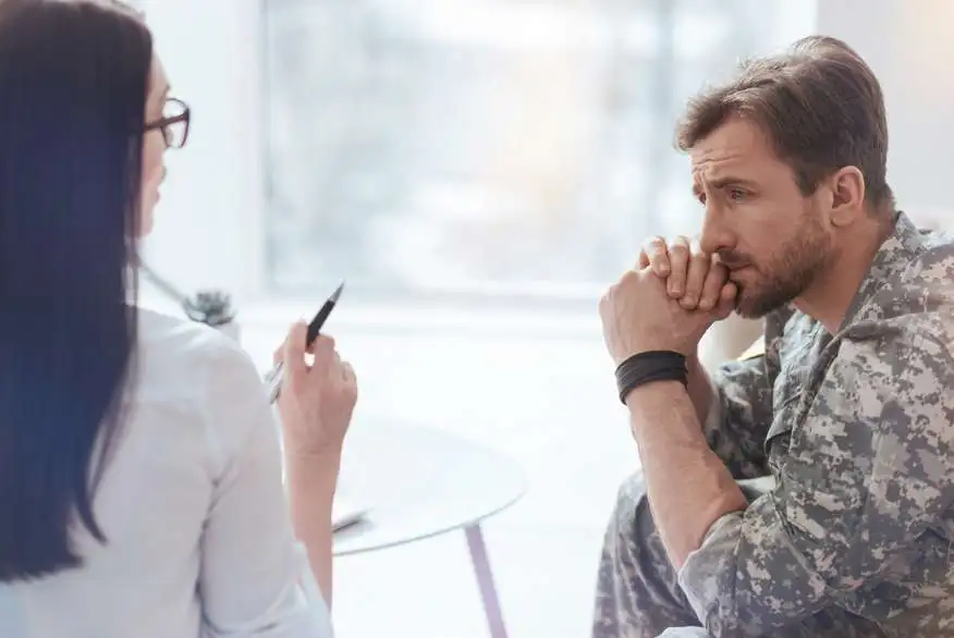 a man is listening intently to a woman talk at a table.